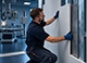 Installer fitting a lead-lined GK-RTG panel to a wall in an X-ray room